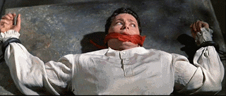 Pendulum about to cut a man in half in the movie "Pit and the Pendulum"