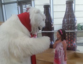 The Coca-Cola Bear at the World of Coca-Cola saying hello to a girl